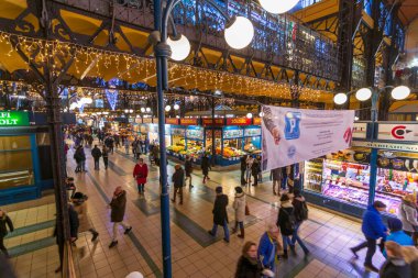 BuDAPEST - 30 Aralık 2019: Budapeşte 'deki renkli Büyük Pazar' ın tadını çıkaran insanlar, yeni yıl arifesi ve yeni dekorasyon arifesinde Noel için süslenmiş ve şenlikli
