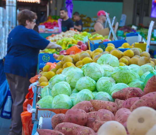 Människor på en isral utomhus frukt och grönsaksmarknad — Stock fotografie