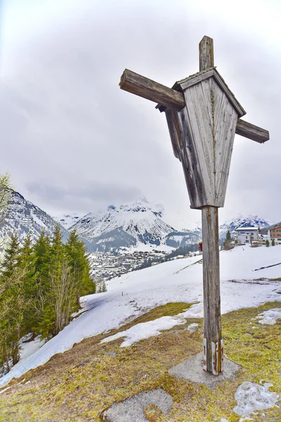 Cross overlooking the ski village of Lech — Stock Photo, Image