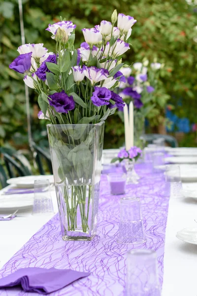 Tavolo esterno allestito per una festa in viola e bianco — Foto Stock