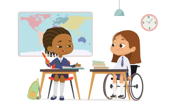 Two diverse schoolgirl in uniform talking at geography lesson studying at multiracial inclusive school vector flat illustration. Girl in wheelchair communicating to classmate learning at classroom — Stock Vector