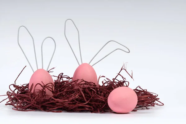 Húsvéti tojás festett rózsaszín, aranyos nyuszi, fehér elszigetelt háttérrel. Koncepció dekoráció boldog húsvétot. Közelkép, szelektív fókusz — Stock Fotó