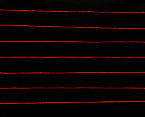Hilo rojo colorido. Líneas horizontales sobre fondo negro aislado. Textura, fondo abstracto, primer plano — Foto de Stock