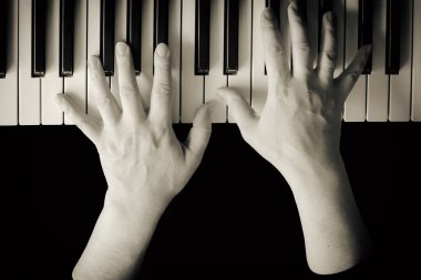 Piyano çalan kadın ellerine yukarıdan seçici bir şekilde odaklan. Yakın çekim, siyah izole katman, kopyalama alanı. Eski renkler. Ev hobileri konsepti otantik