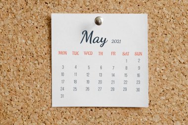 Takvimin tam aylık sayfası: Mayıs 2021. Beyaz takvim kağıdı kahverengi mantar panoya iliştirilmiş. Takvim tarihi kavramı.