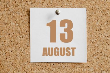 13 Ağustosta. Ayın 13 'ü, takvim tarihi. Beyaz takvim kağıdı kahverengi mantar panoya takılı. Yaz ayı, yılın günü konsepti..