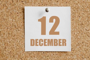 12 Aralık. Ayın 12. günü, takvim tarihi. Kahverengi mantar panoya takılı beyaz takvim kağıdı. Kış ayı, yılın günü konsepti..