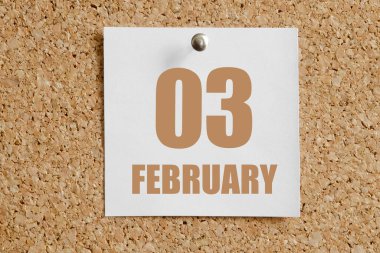 Şubat 03. Ayın 03. günü, takvim tarihi. Kahverengi mantar panoya eklenmiş beyaz takvim kağıdı. Kış ayı, yılın günü konsepti..