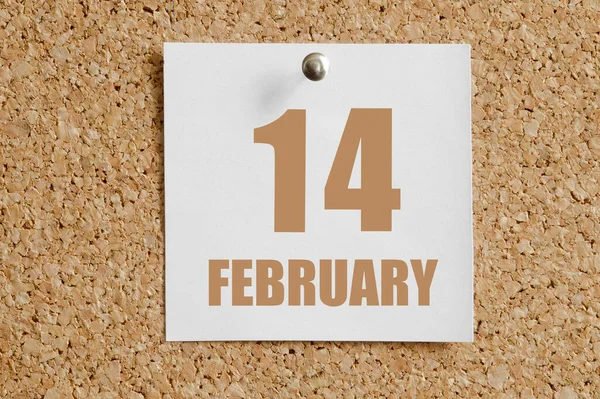 february 14. 14th day of the month, calendar date.White calendar sheet attached to brown cork board. Winter month, day of the year concept.