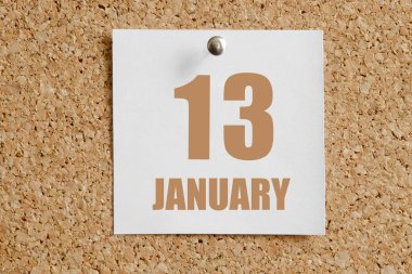 13 Ocak. Ayın 13 'ü, takvim tarihi. Beyaz takvim kağıdı kahverengi mantar panoya takılı. Kış ayı, yılın günü konsepti..
