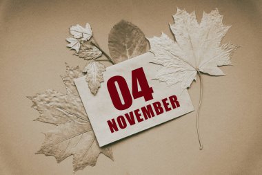 Kasım 04 'te. Ayın 04. günü, takvim tarihi. Üzerinde tarih ve ay olan zarf, kahverengi arka planda sonbahar yapraklarıyla çevrili. Sonbahar ayı, yılın günü konsepti..