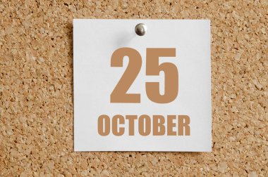 25 Ekim. Ayın 25. günü, takvim tarihi. Kahverengi mantar panoya eklenmiş beyaz takvim kağıdı. Sonbahar ayı, yılın günü konsepti..