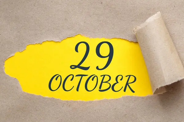 10月29日 月の29日 カレンダーの日付 端が引き裂かれた紙の穴 ギザギザの穴から黄色の背景が見える 秋の月 その年のコンセプトの日 — ストック写真
