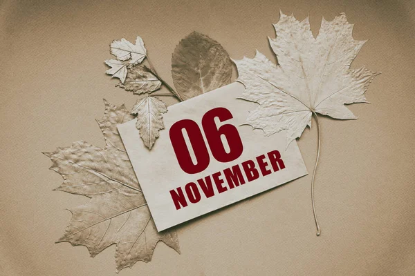 11月6日 カレンダーの日付の06日日付と月 茶色の背景に秋の葉に囲まれたエンベロープ 秋の月 年の概念の日 — ストック写真