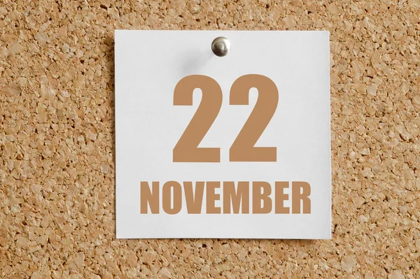 22. listopadu. 22. den v měsíci, kalendářní datum.Bílý kalendářní list přiložen k hnědé korkové tabuli.Podzimní měsíc, den koncepce roku — Stock fotografie