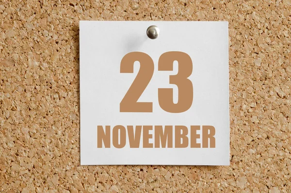 23. listopadu. 23. den v měsíci, kalendářní datum.Bílý kalendářní list přiložen k hnědé korkové tabuli.Podzimní měsíc, den koncepce roku — Stock fotografie
