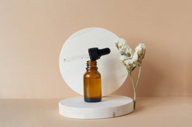 Arka planda iki yuvarlak ahşap standın açık kapağı olan kahverengi cam şişenin maketi. Sahnenin yanında kurumuş çiçek bulunmaktadır. Kozmetik ürünlerinin sunumu için 3d podyum kavramı