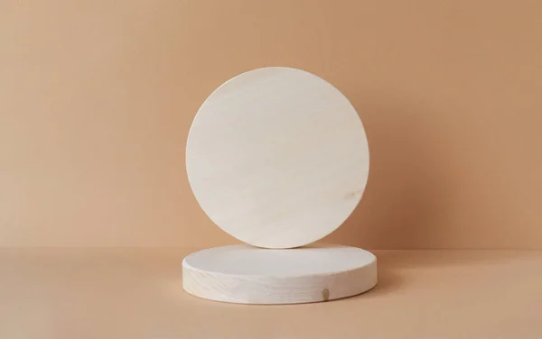 Bej izole arka planda iki yuvarlak ahşap figür. Mal ve kozmetik sunumu için geometrik 3d podyum kavramı.