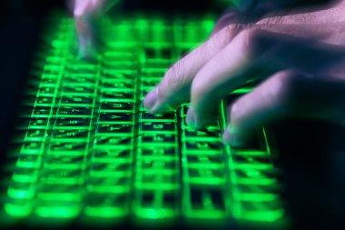 Klavyede hareket bulanıklığı olan yeşil ışıkta yazan eller siber suç bulutu hackleme güvenliği kavramı.