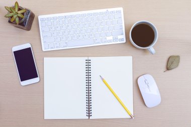 Ofis masasında bilgisayar, defter, çiçek ve kahve fincanı var. Kopyalama alanı olan üst görünüm