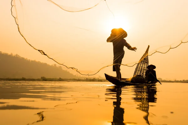 Silhueta da Ásia Pescador no barco na hora da manhã nascer do sol — Fotografia de Stock