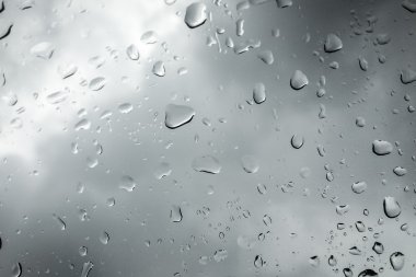 Yağmur damlaları pencere bölmesinde bir bulutlu gün