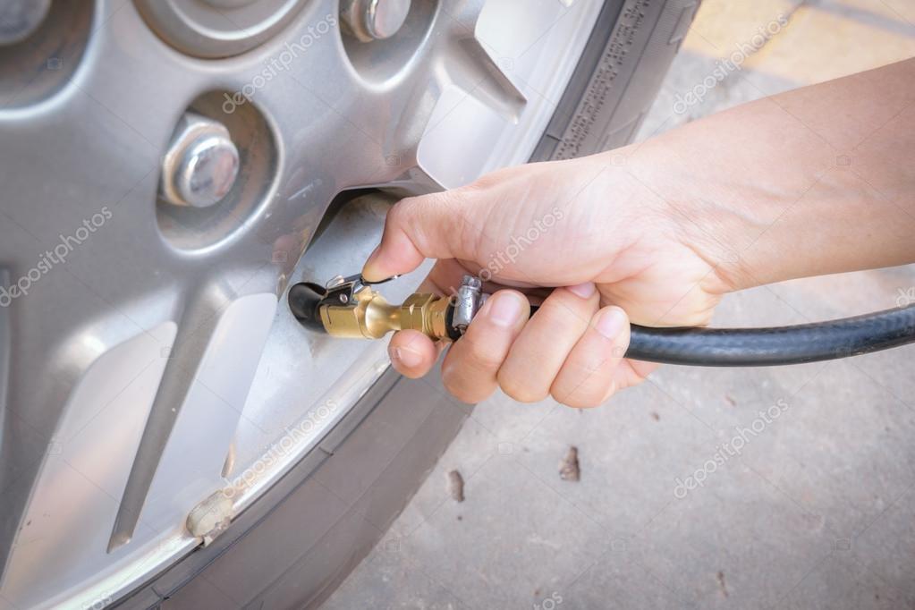 Filling air into a car tire Stock Photo by ©jes2uphoto 117291150