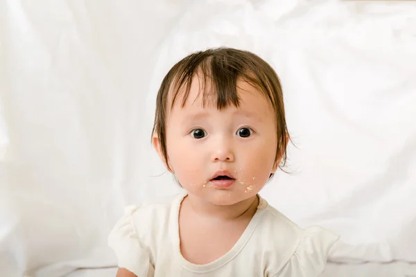 Bambino ragazza mangiare occhio guardando a madre, sporco faccia — Foto Stock