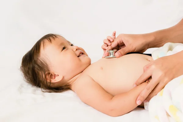 Médico examina asiático bebé con estetoscopio, enfoque seleccionado —  Fotos de Stock