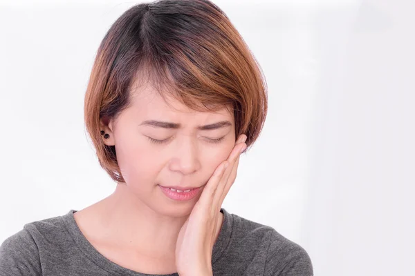 Женщина имеет зубную боль на белом фоне, симптомы зубной боли, как правило, связаны с какой-то боли или боли в челюстях, деснах — стоковое фото