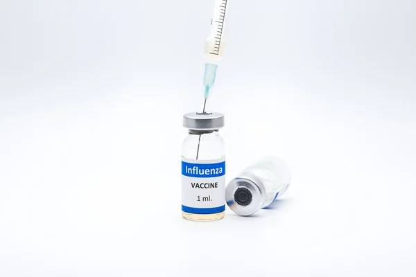 Vacina contra a gripe e seringa sobre fundo branco — Fotografia de Stock