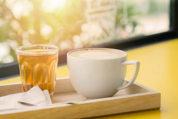 Taza de café blanco sobre mesa de madera fondo de enfoque suave con iluminación trasera — Foto de Stock