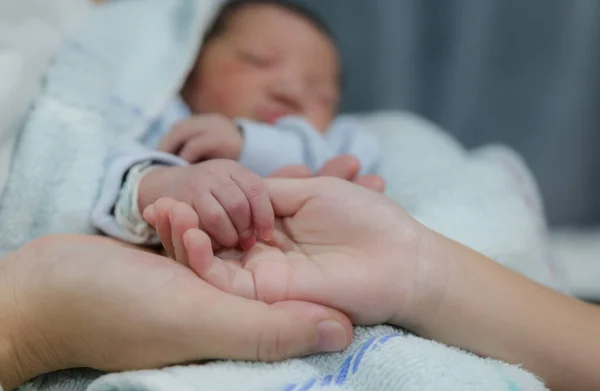 Anne ve kızı yeni doğmuş bebek kardeş parmağı tutuyorlar. — Stok fotoğraf