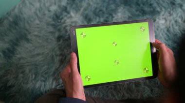 Dijital tablet görünümlü krom anahtar yeşil ekran bir halıya yakın