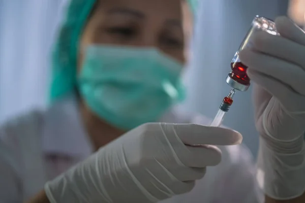 Los médicos llenan la jeringa con un vial de medicamento en las manos de una enfermera, el médico prepara la administración de la inyección al paciente. concepto de medicina — Foto de Stock