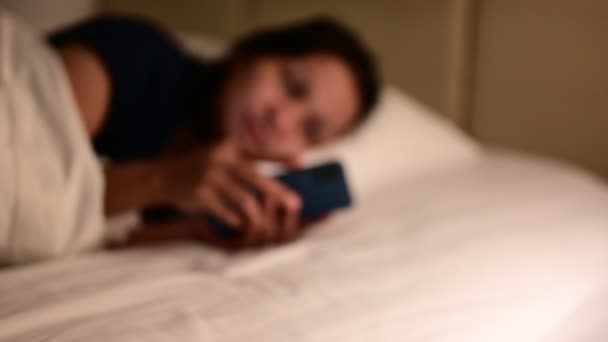 Nő tesz okos telefon az asztalra, és kapcsolja ki a villanykapcsolót az ágy mellett a hálószobában késő éjjel kész aludni. Szép álmokat és pihenést. — Stock videók