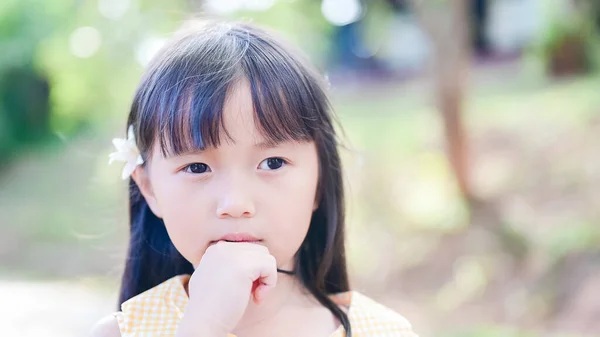 Roztomilý malý asijské dívka zastrčit bílý květ v jeho uchu a podívat se na fotoaparát — Stock fotografie