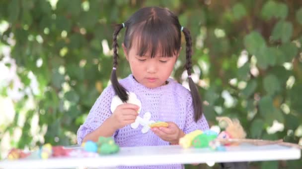 작은 소녀가 플라스틱 점토 장난감을 조각하고, 창의성을 지지하고, 경험을 통해 배우고, — 비디오