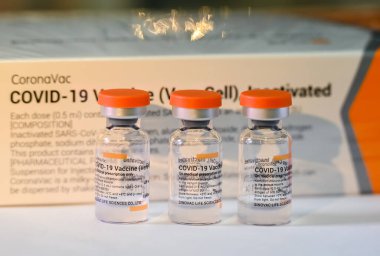 Thailand - June 5 , 2021 Close up of Sinovac Vaccine vials bottles for can help stop pandemic ,COVID-19 vaccines can help reduce the transmission of the new coronavirus from person to person clipart