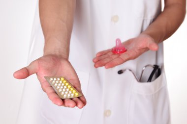Doğum kontrol hapları bir doktor, oral kontraseptifler veya prezervatif arasında seç için kavram elinde.