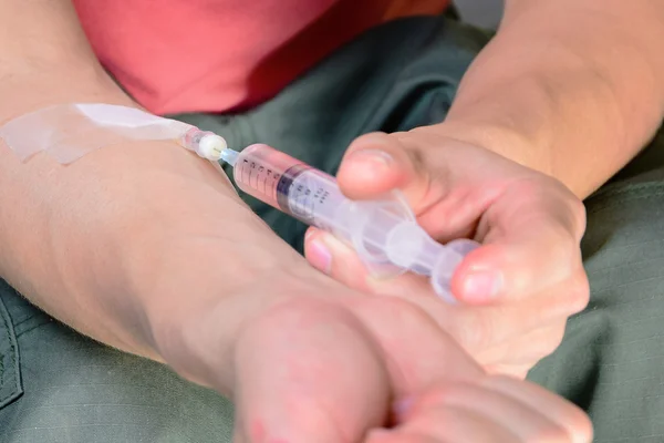 Drug addict young man with syringe in action — Stock Photo, Image