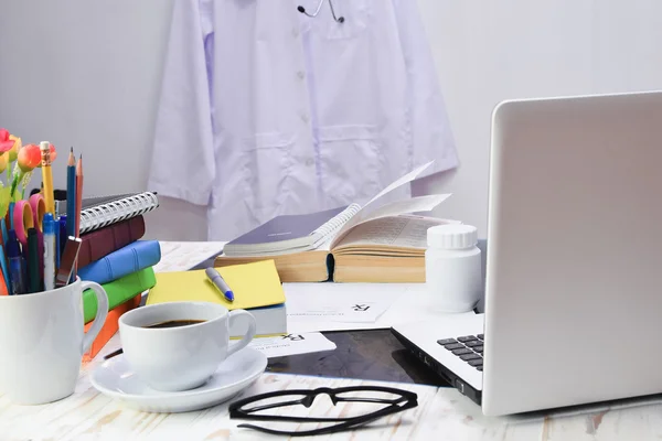 Una pila di libri sulla scrivania del medico e stoffa appesa al muro — Foto Stock