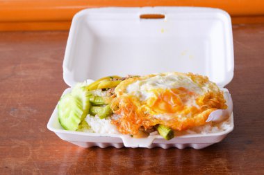 Beslenme çantası, domuz eti ve köpük kutusunun kızarmış yumurta ile kızarmış pilav.