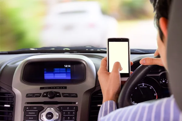 Driving while holding a mobile phone (cell phone use while driving) — Stockfoto