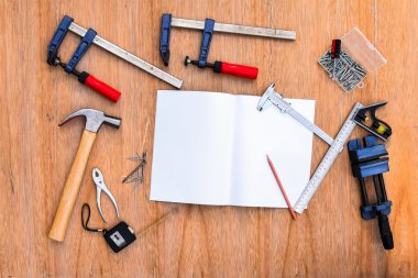 Worktools, koleksiyon küme araçları çalışma. (Çelik anahtarı, çekiç, çivi, cıvata, somun anahtarları, vb) defter ile ahşap masa.