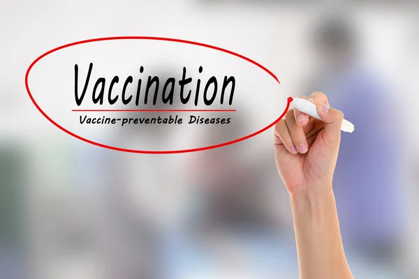 Médico escribiendo a mano Vacunación, enfermedades prevenibles con vacunas en la pantalla visual. con la inyección borrosa de la vacuna . — Foto de Stock