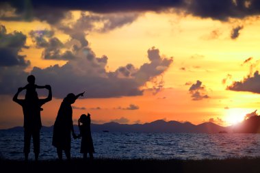 Bir mutlu aile, anne, baba, kız, oğlu ve bebek (kadınlar hamilelik) sunsetbach (kopya alanı veya metin doğru alan üzerinde üzerinde silüeti)