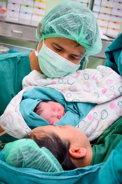 Новорожденный ребенок с матерью и отцом в операционной — стоковое фото