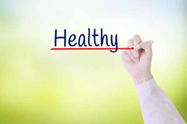 Doctor hand writing unHealthy ,Healthy with marker on   on visual screen over green nature blurred background. — Stock Photo, Image