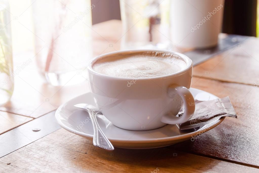 A cup of coffee on wooden table.